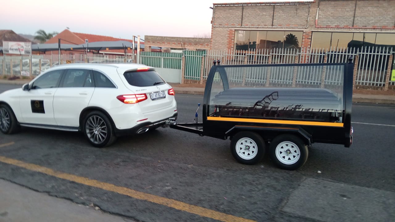 Coffin-class hearse trailer behind Mercedes-Benz GLC